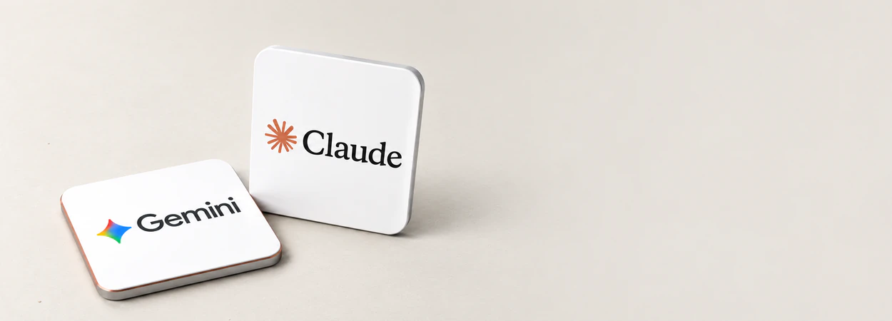 Claude and Gemini subscription cards on a desk