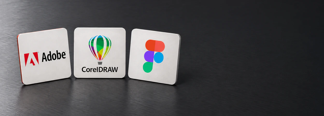 Adobe, CorelDRAW and Figma design cards standing on a desk
